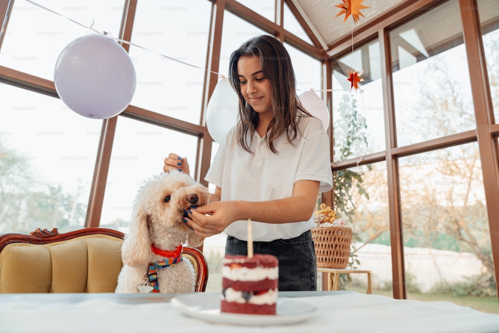 a woman cutting a cake with a dog on her lap