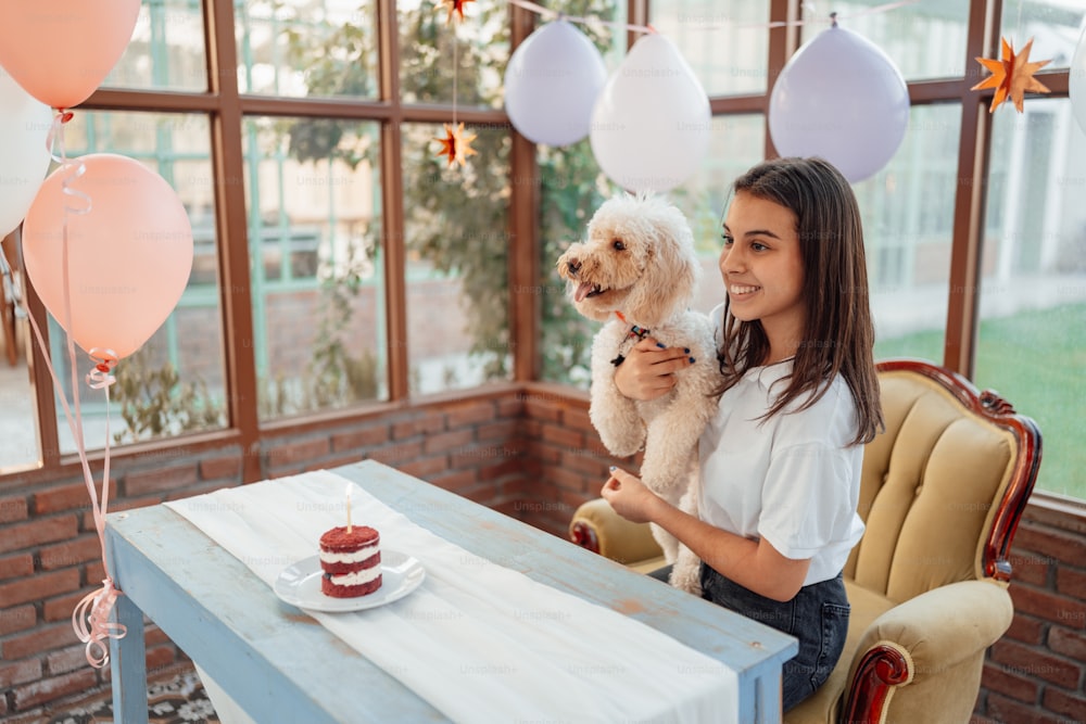 a woman sitting at a table holding a dog