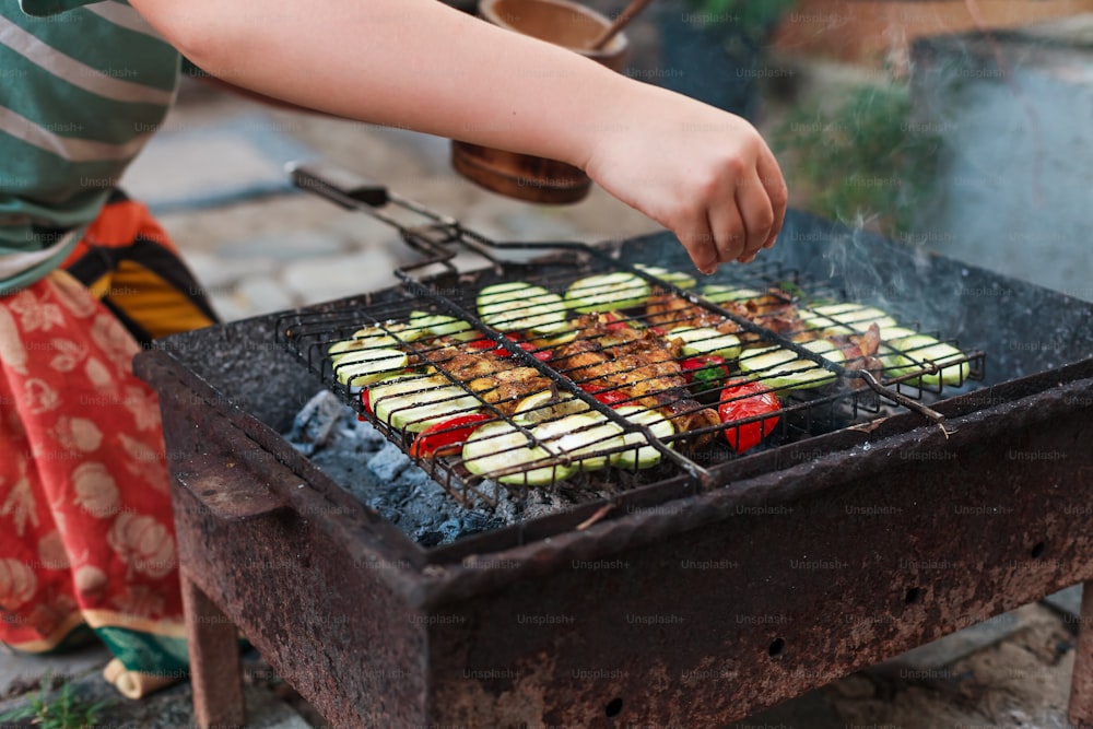 a person cooking food on top of a grill