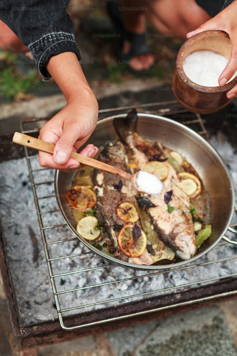 Una persona está cocinando pescado en una parrilla