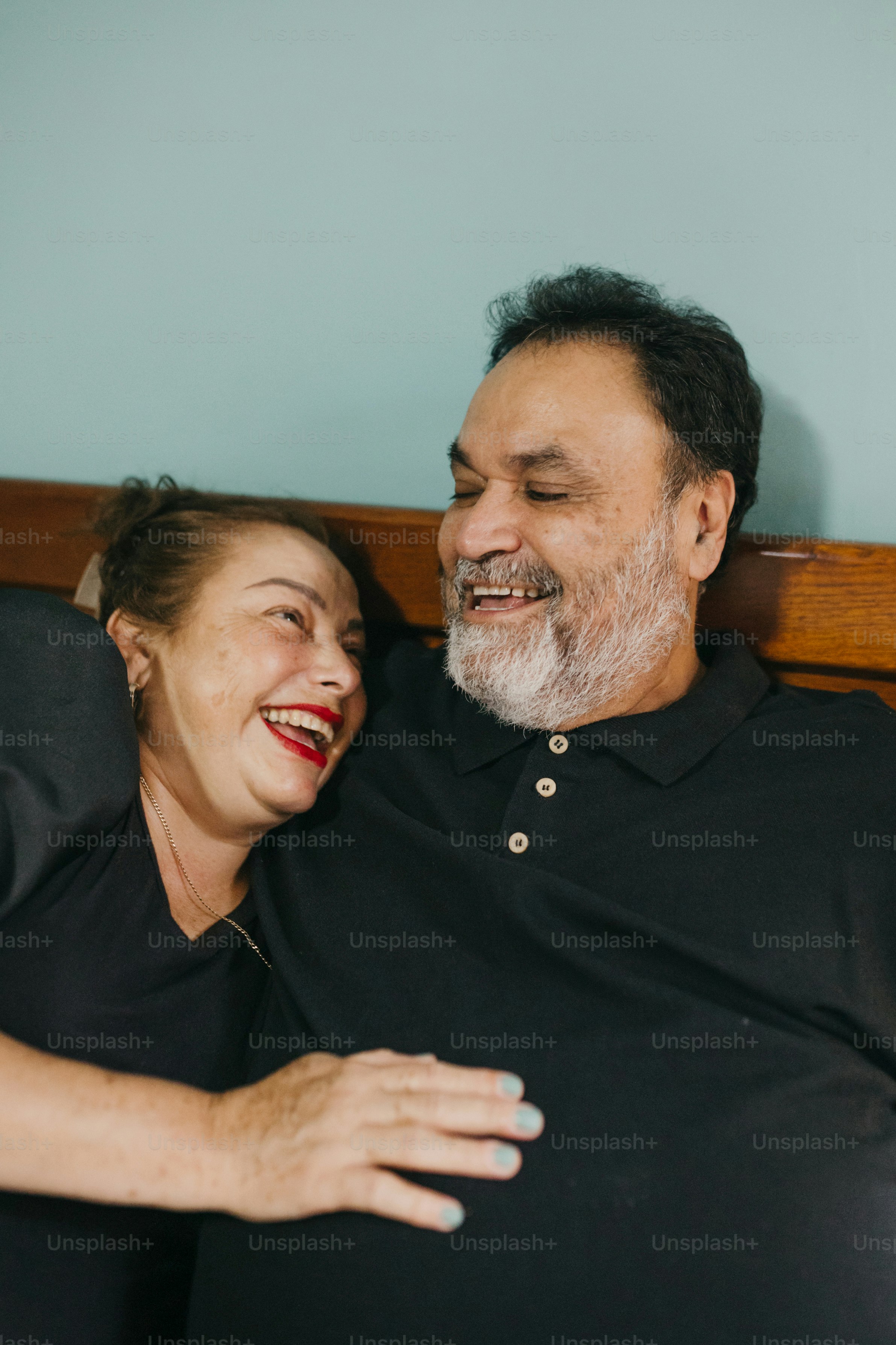 Foto Un hombre y una mujer acostados encima de una cama – Diversidad ...