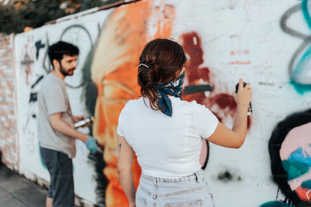 Un uomo e una donna che dipingono un muro
