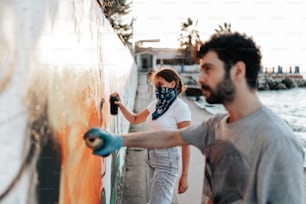 Un hombre y una mujer pintando una pared