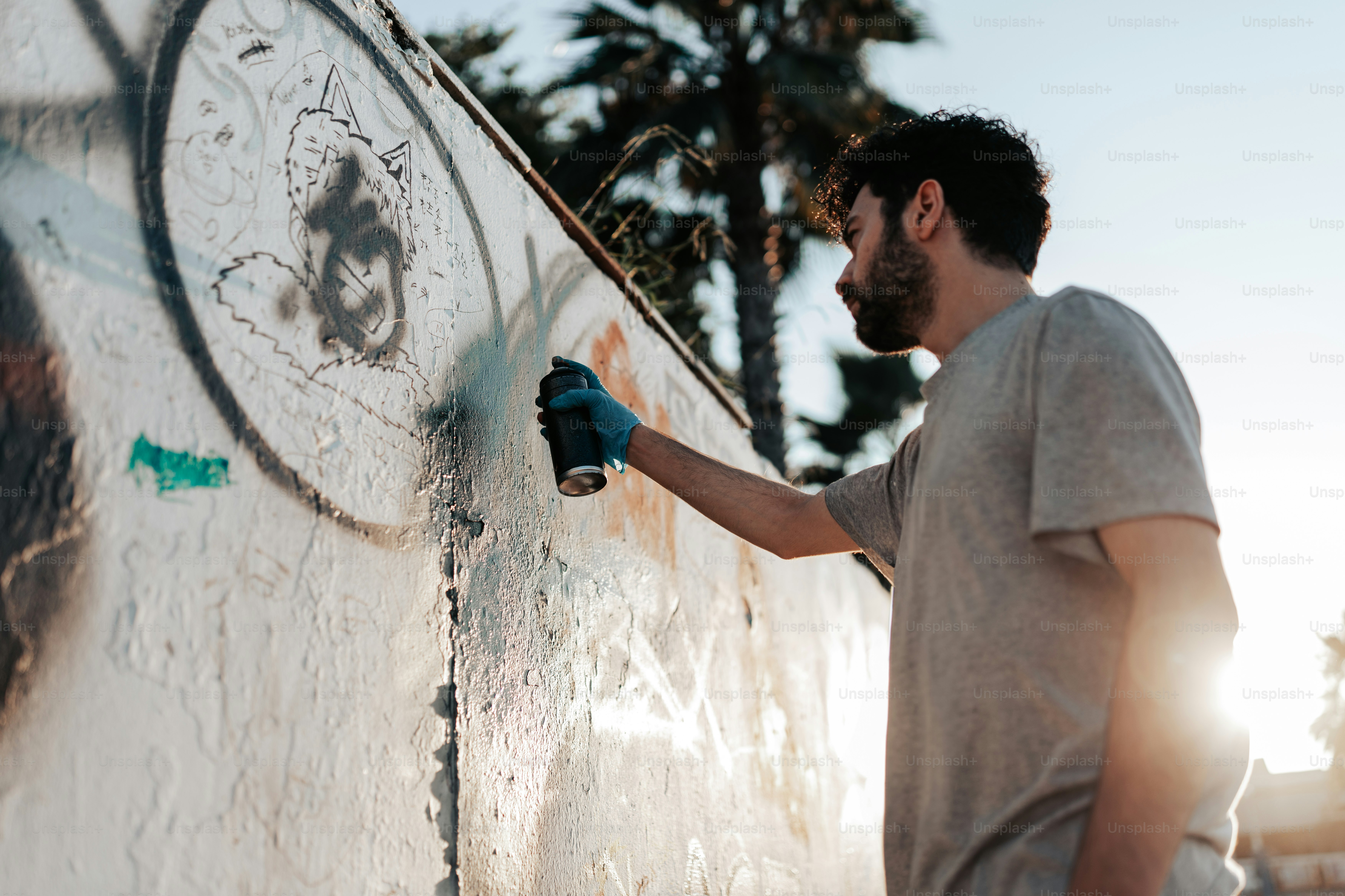 Una mujer parada frente a una pared con graffiti foto – Imagen de ...