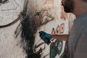 a man is painting a wall with graffiti