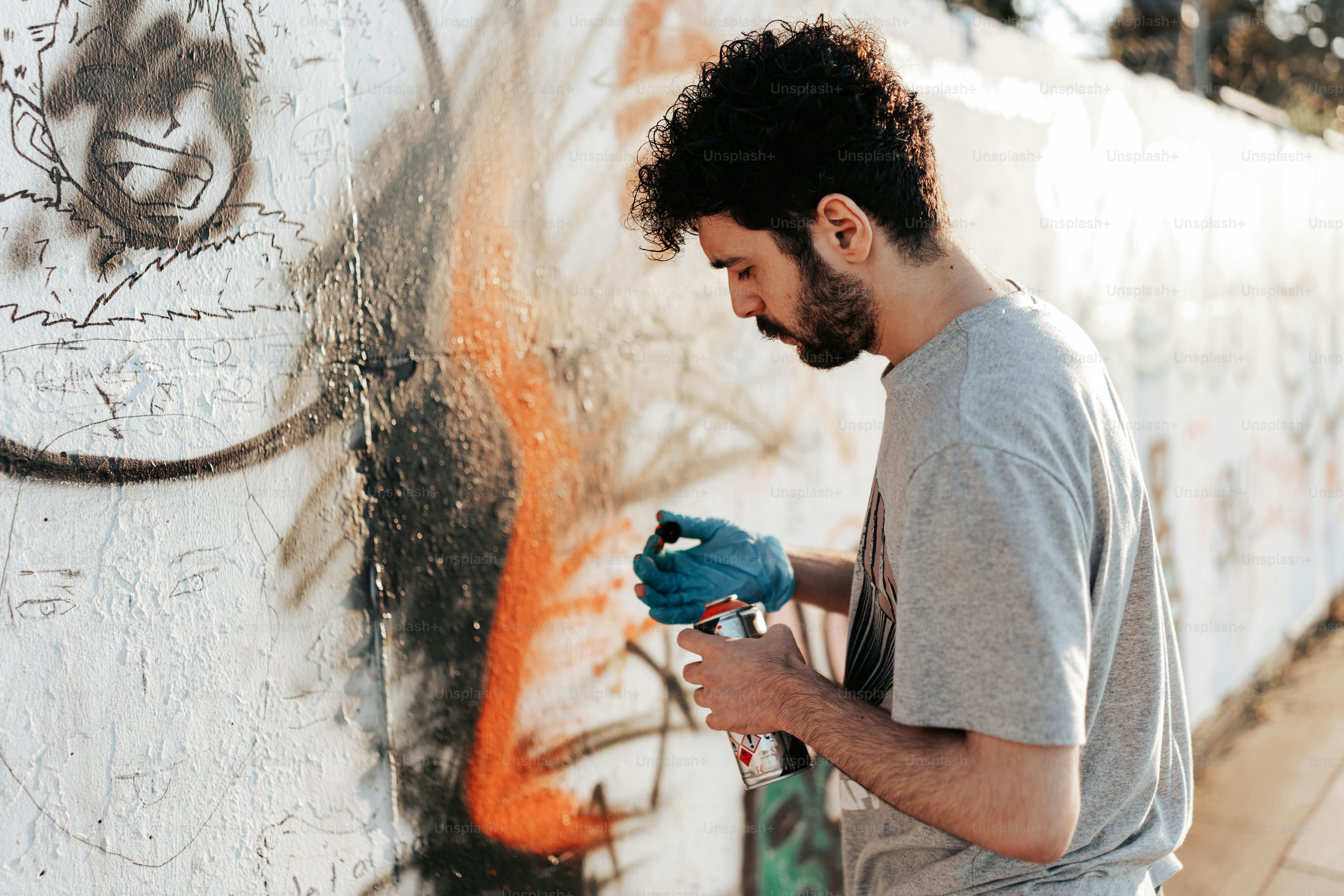 A man spray painting graffiti on a wall photo – Graffiti Image on Unsplash
