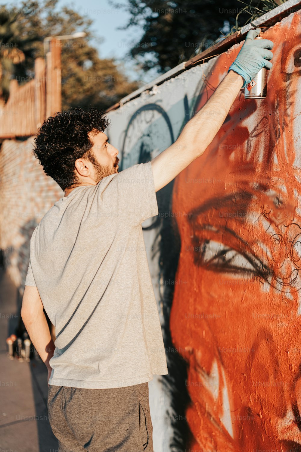 a man painting a wall with graffiti on it