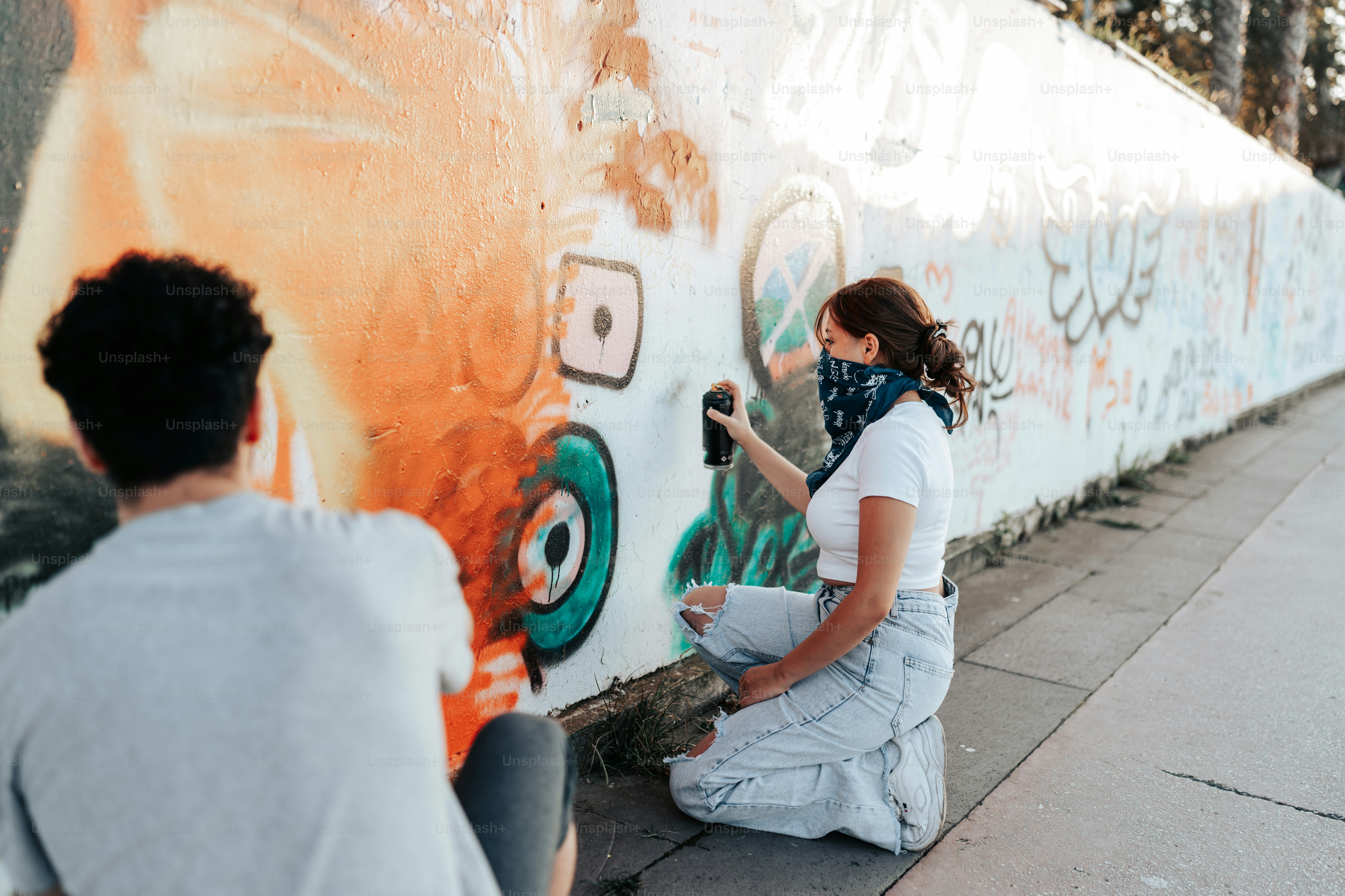 Una mujer parada frente a una pared con graffiti foto – Imagen de ...