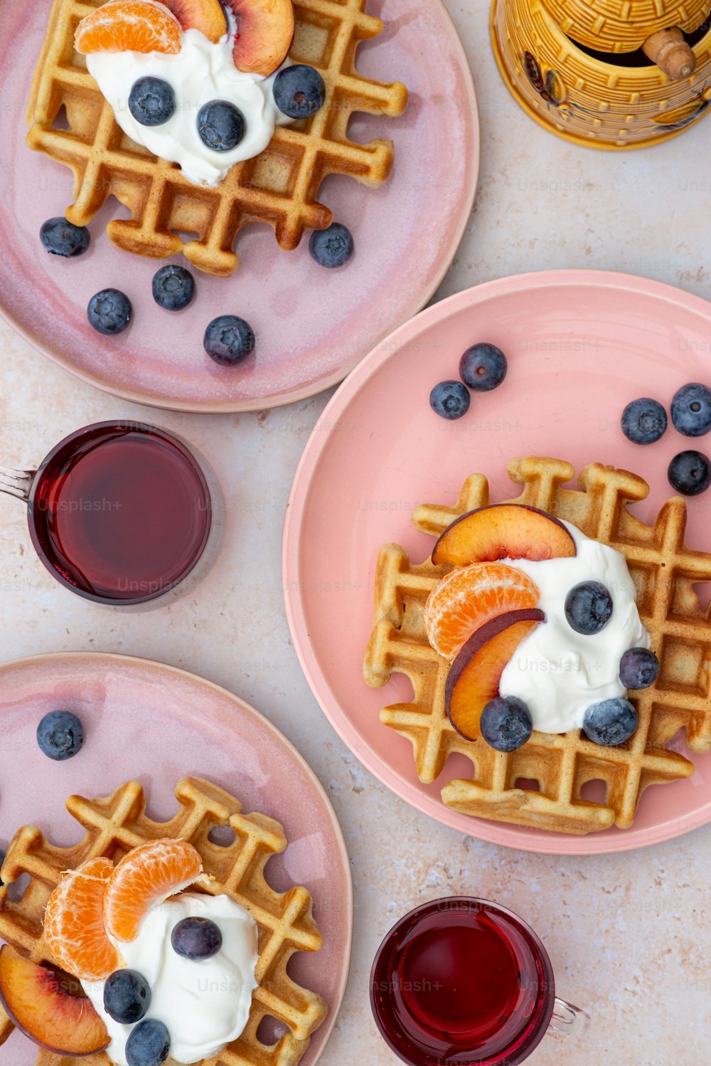 three plates of waffles topped with fruit and yogurt