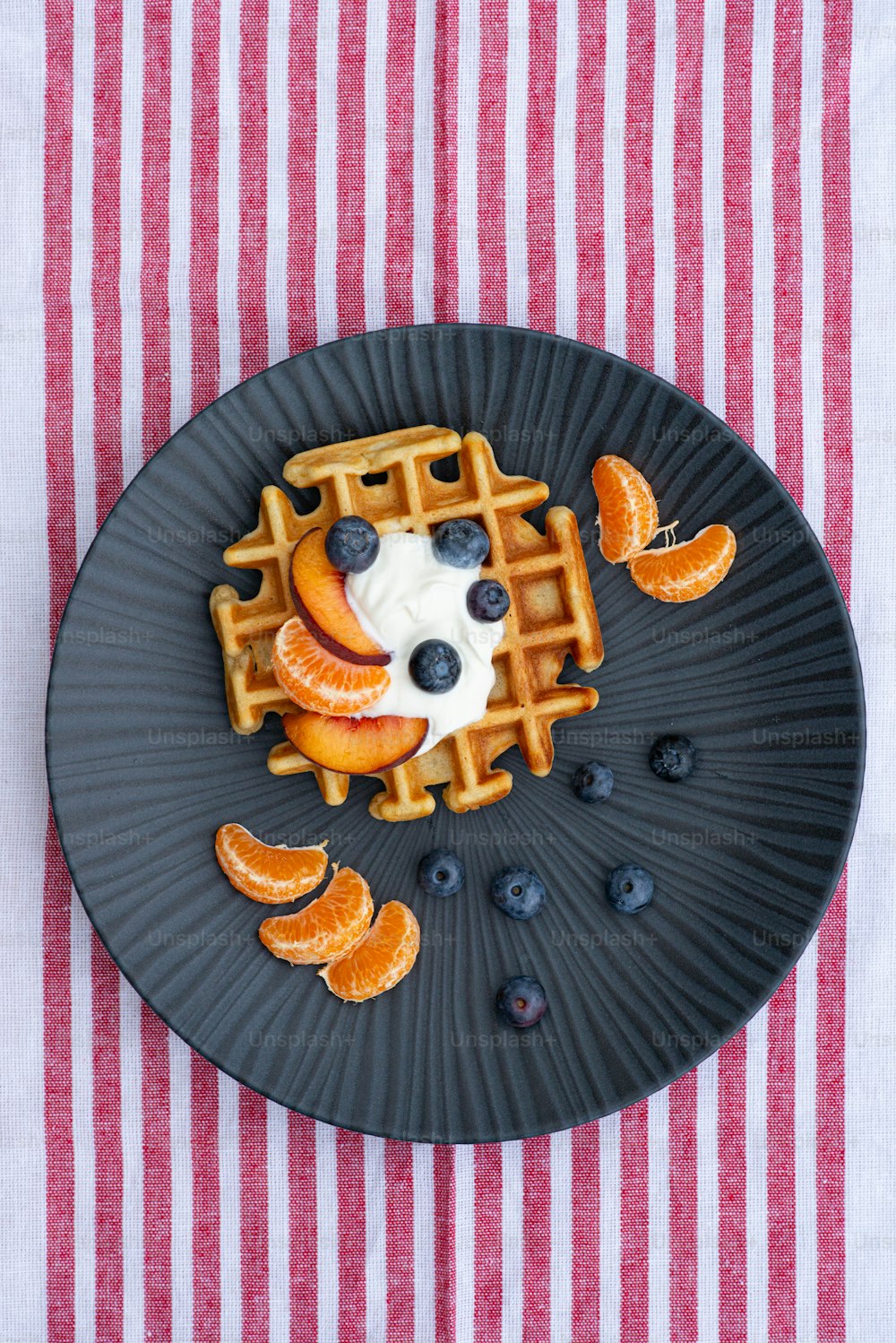 a plate topped with waffles covered in fruit