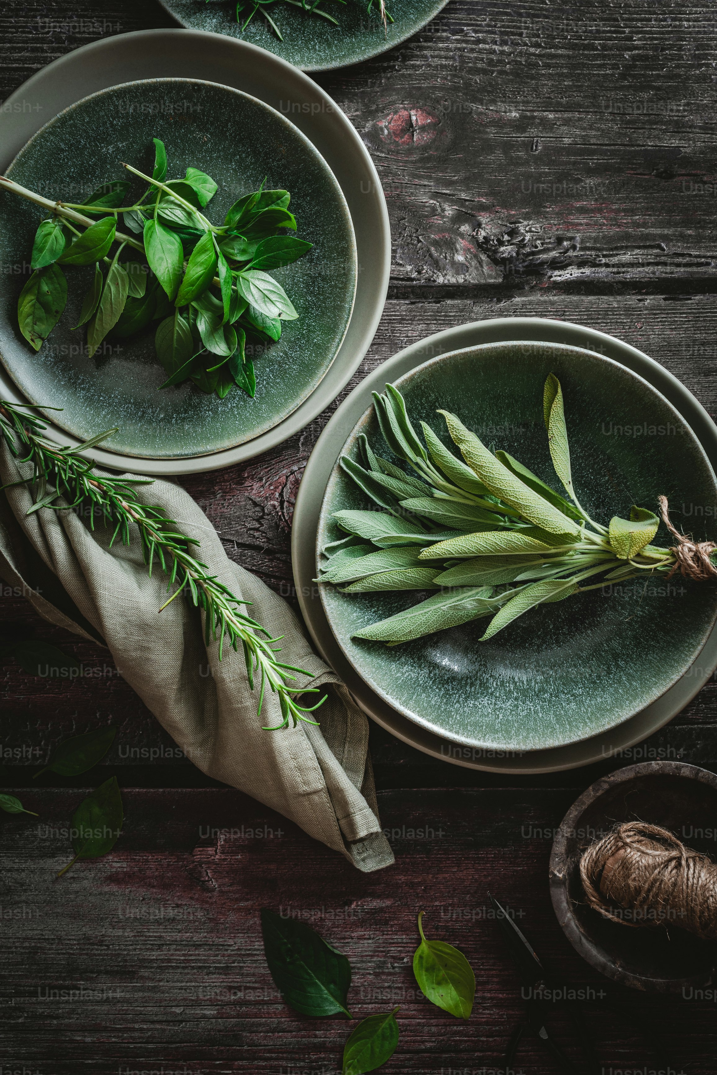 Una mesa cubierta con platos y cuencos llenos de verduras verdes