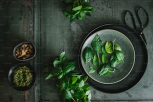 a plate of spinach and a bowl of pesto