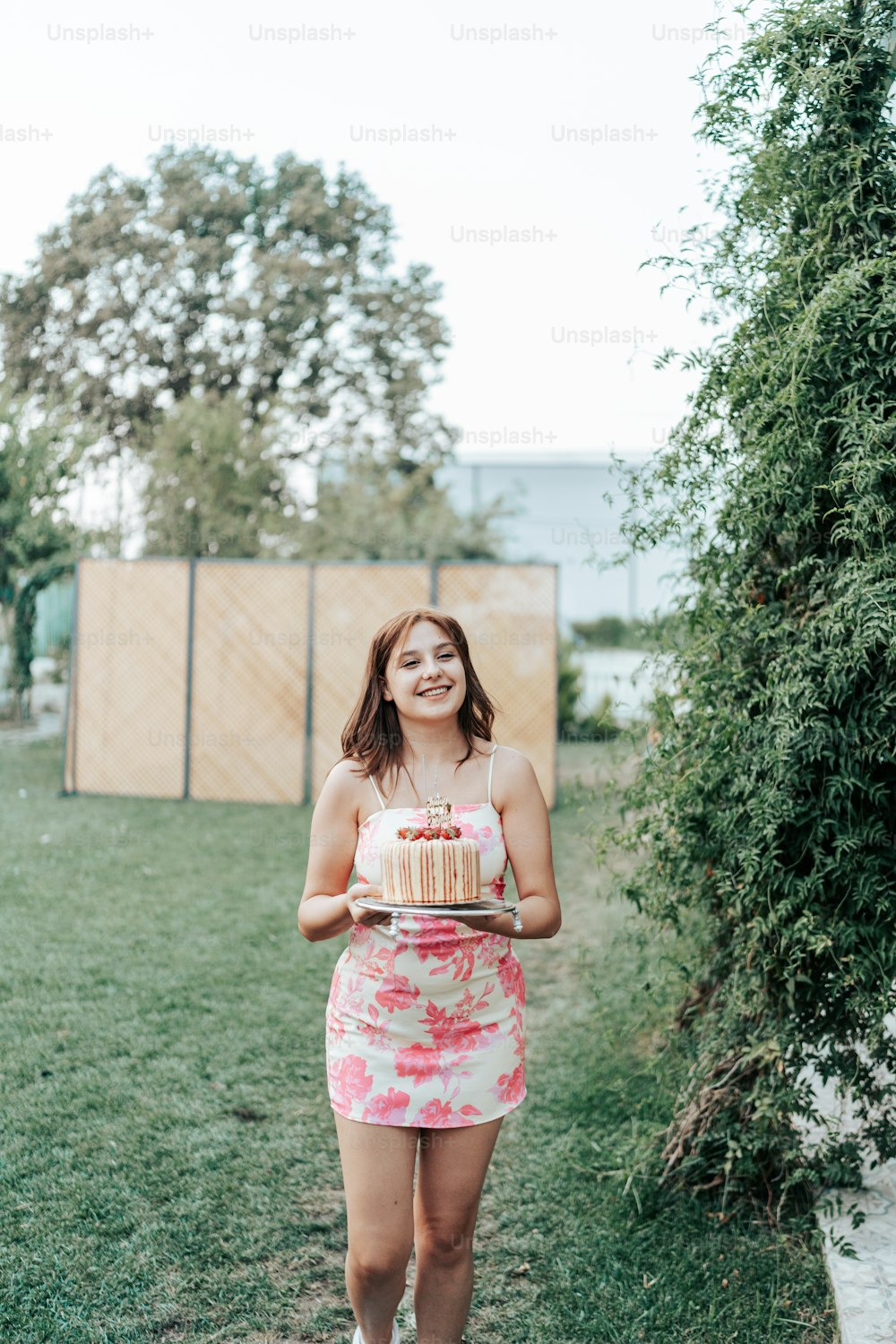a woman in a dress holding a cake