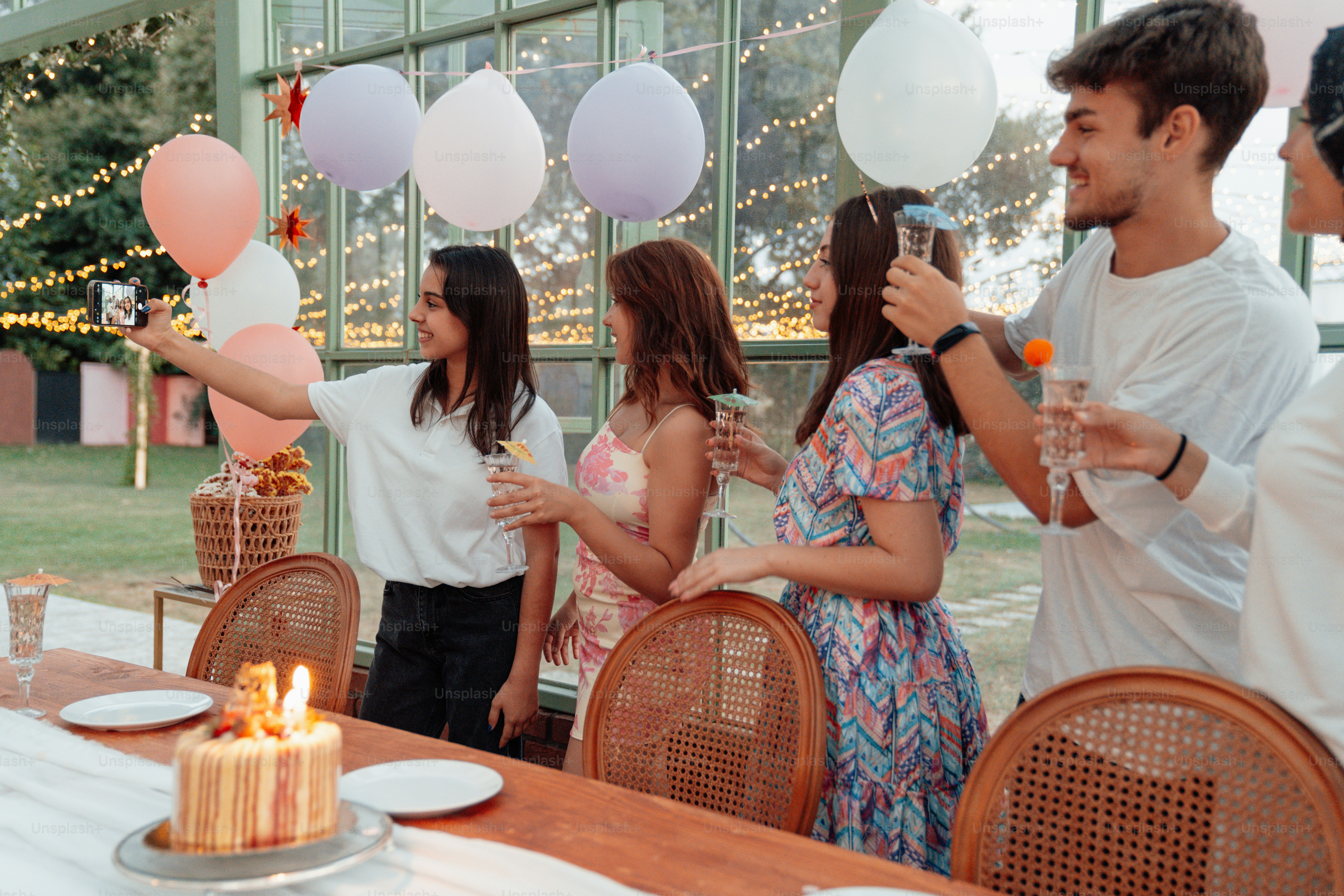 a group of people standing around a table with a cake
