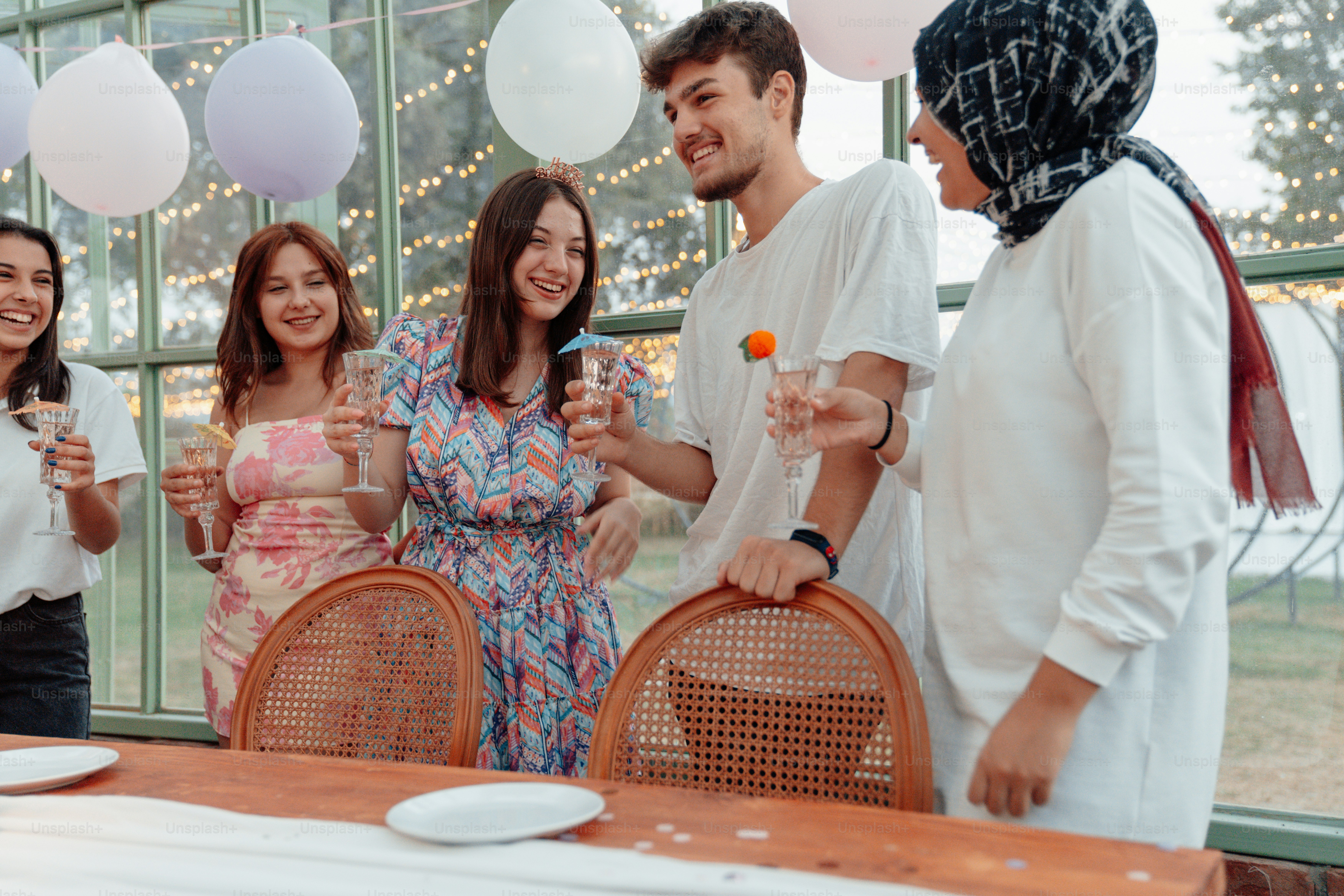 a group of people standing around a table with drinks