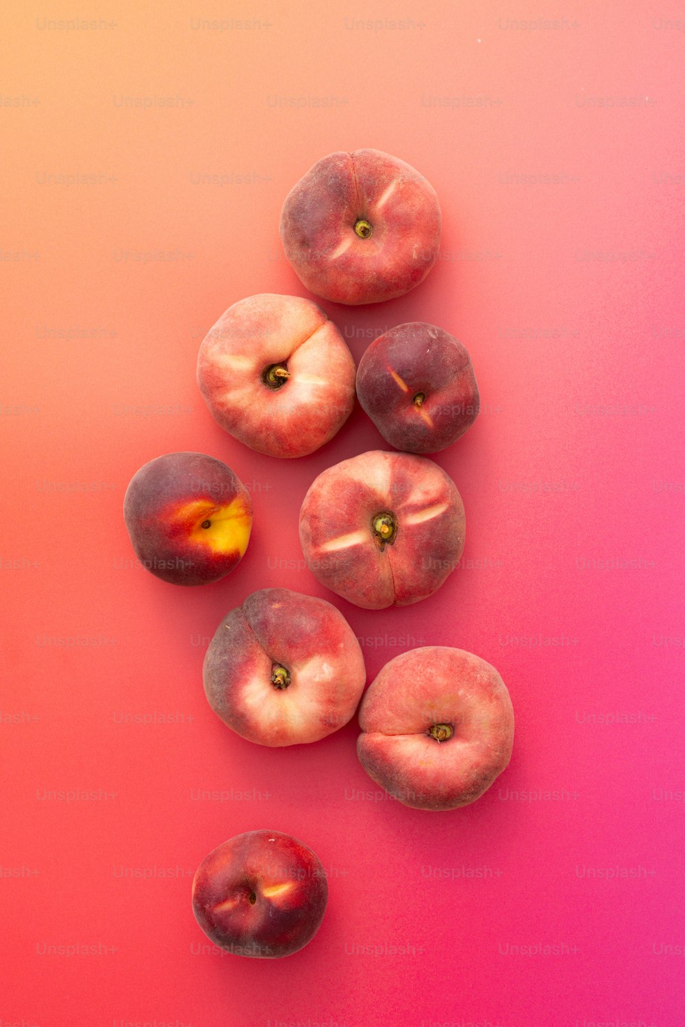 eine Gruppe von Pfirsichen auf rosa und rosa Hintergrund