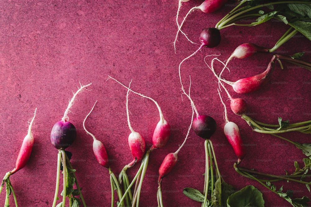 a bunch of radishes on a purple surface