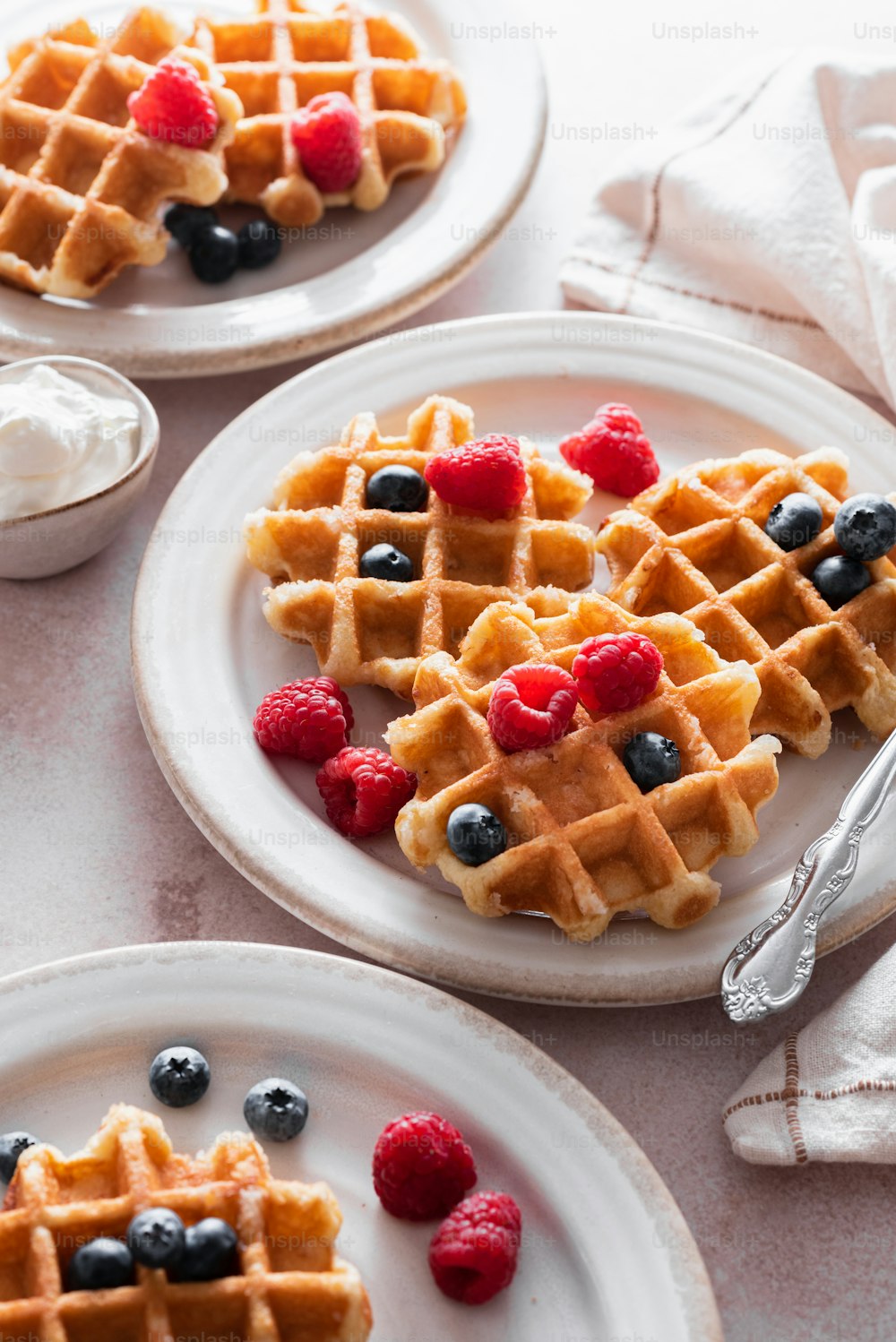 a plate of waffles with berries and blueberries