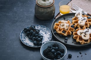 a plate of waffles topped with bananas and blueberries