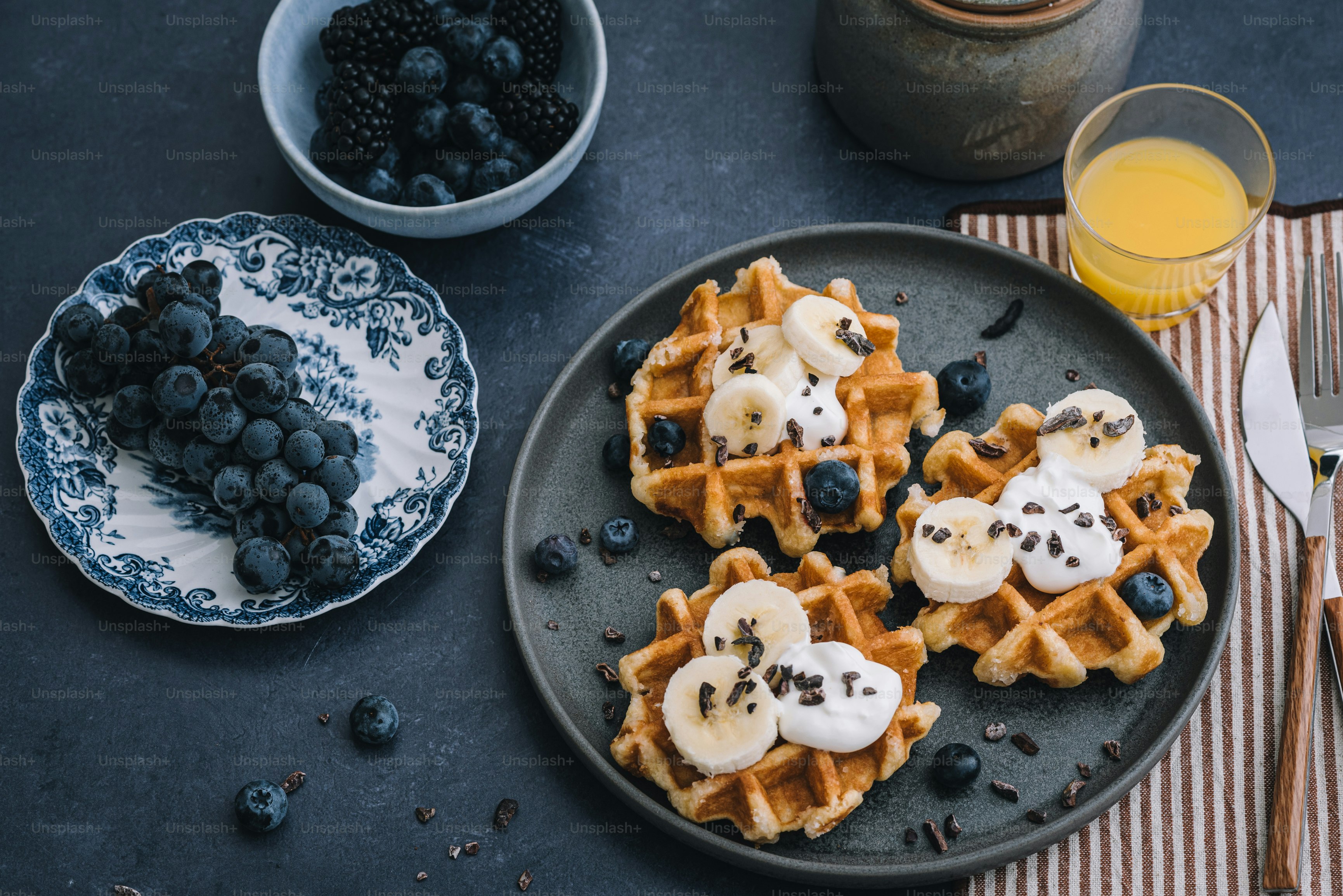 um prato de waffles coberto com bananas e mirtilos