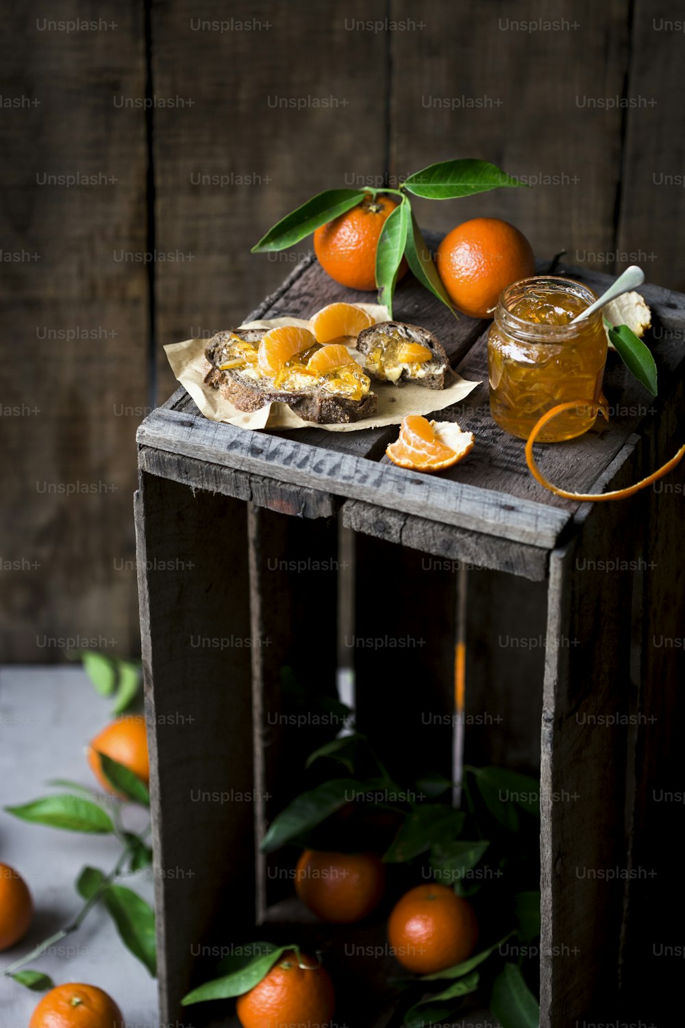 a wooden crate filled with oranges next to a jar of honey
