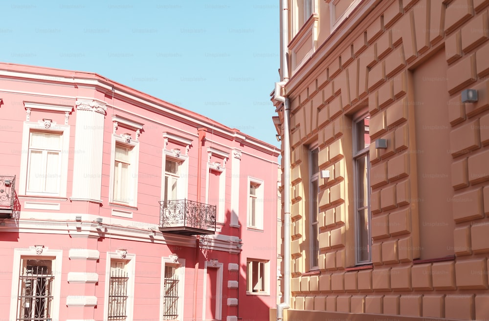 un bâtiment rose avec une horloge sur le devant