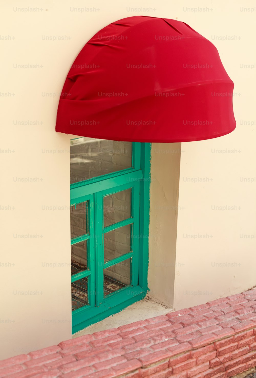 a red hat on top of a green door