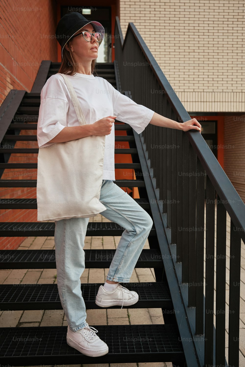 a woman standing on a stair case holding a bag