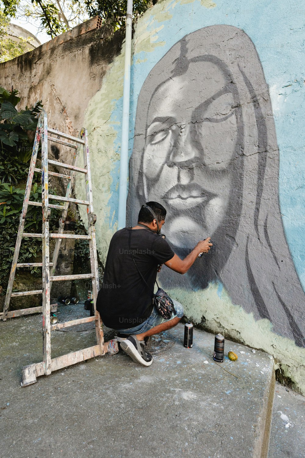 a man is painting a mural on the side of a building