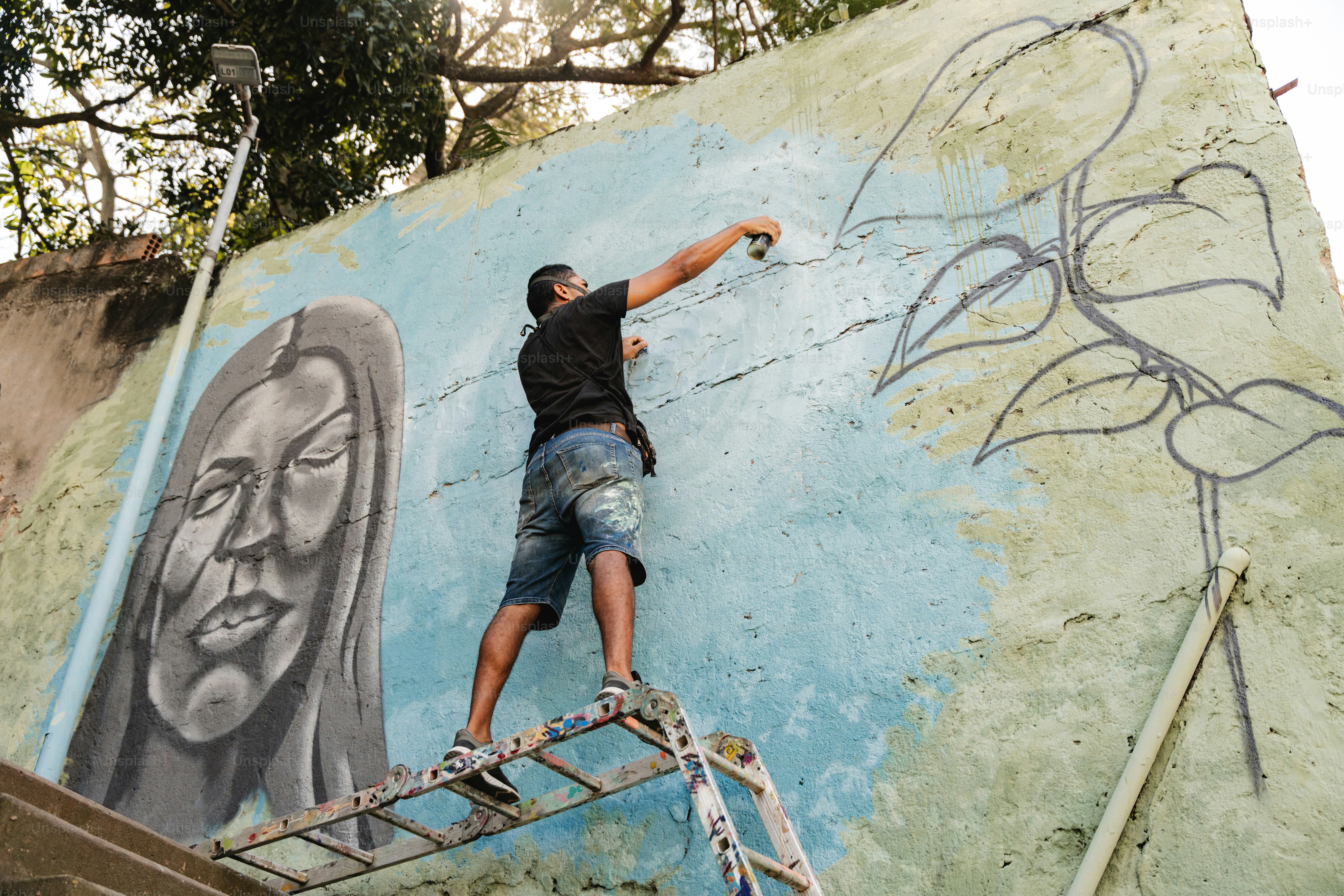 a man is painting a mural on a wall