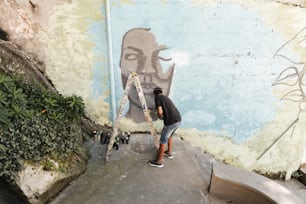Ein Mann, der ein Wandgemälde an der Seite eines Gebäudes malt