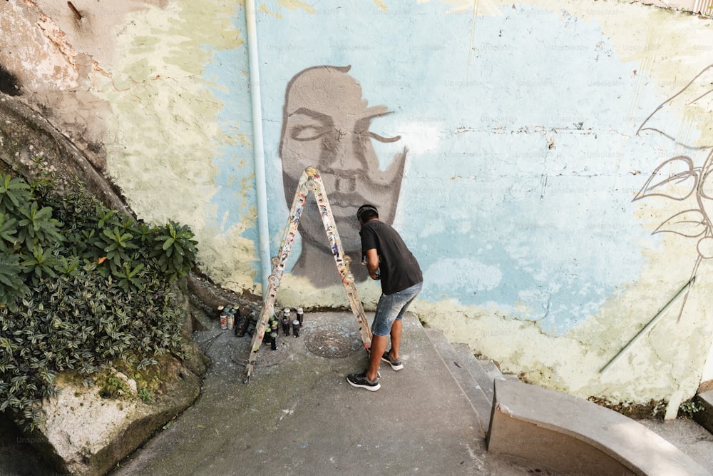 a man painting a mural on the side of a building