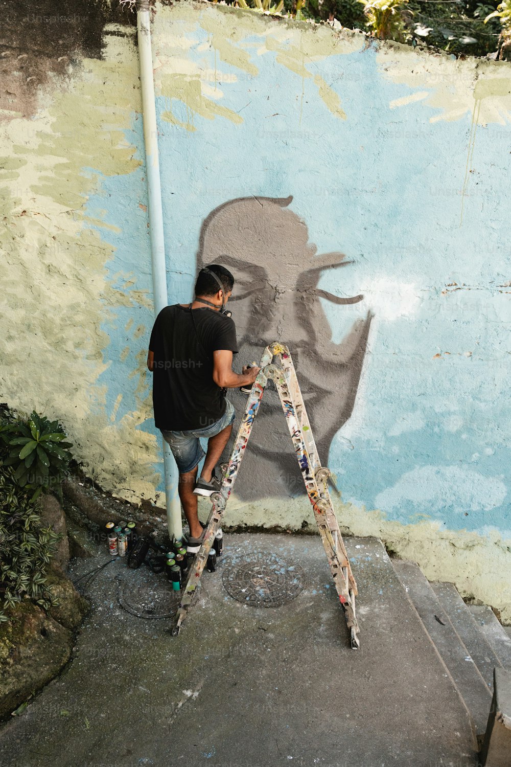 Ein Mann malt ein Wandbild an eine Wand
