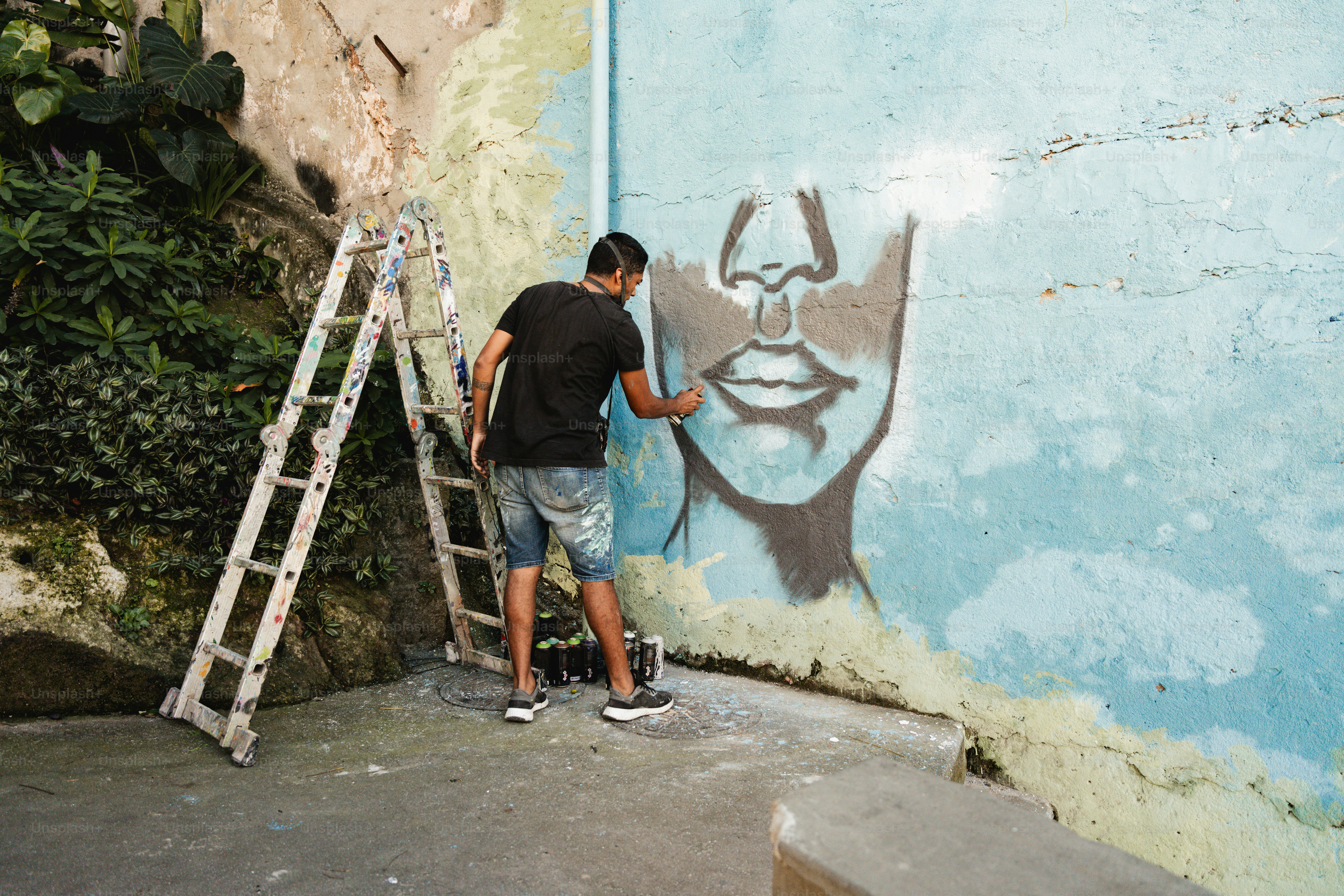 a man painting a face on the side of a building