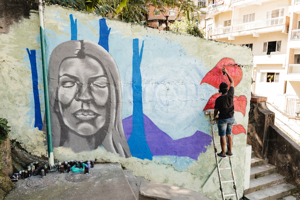 a man is painting a mural on a wall