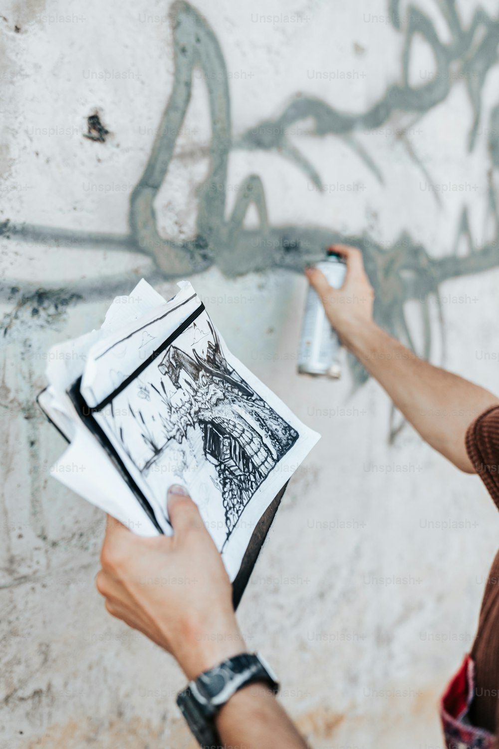 Ein Mann bemalt eine Wand mit Graffiti