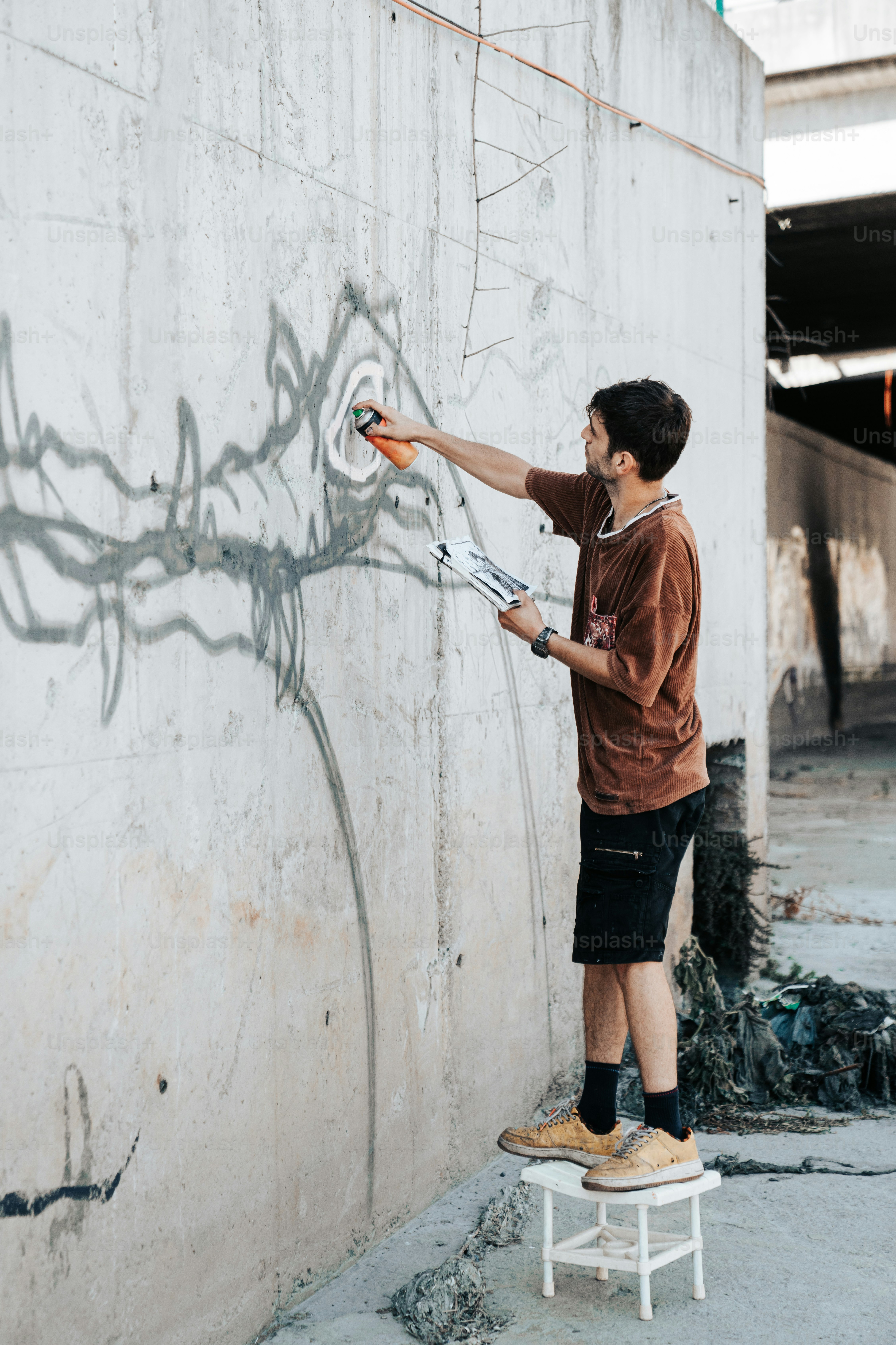 a man painting graffiti on the side of a building