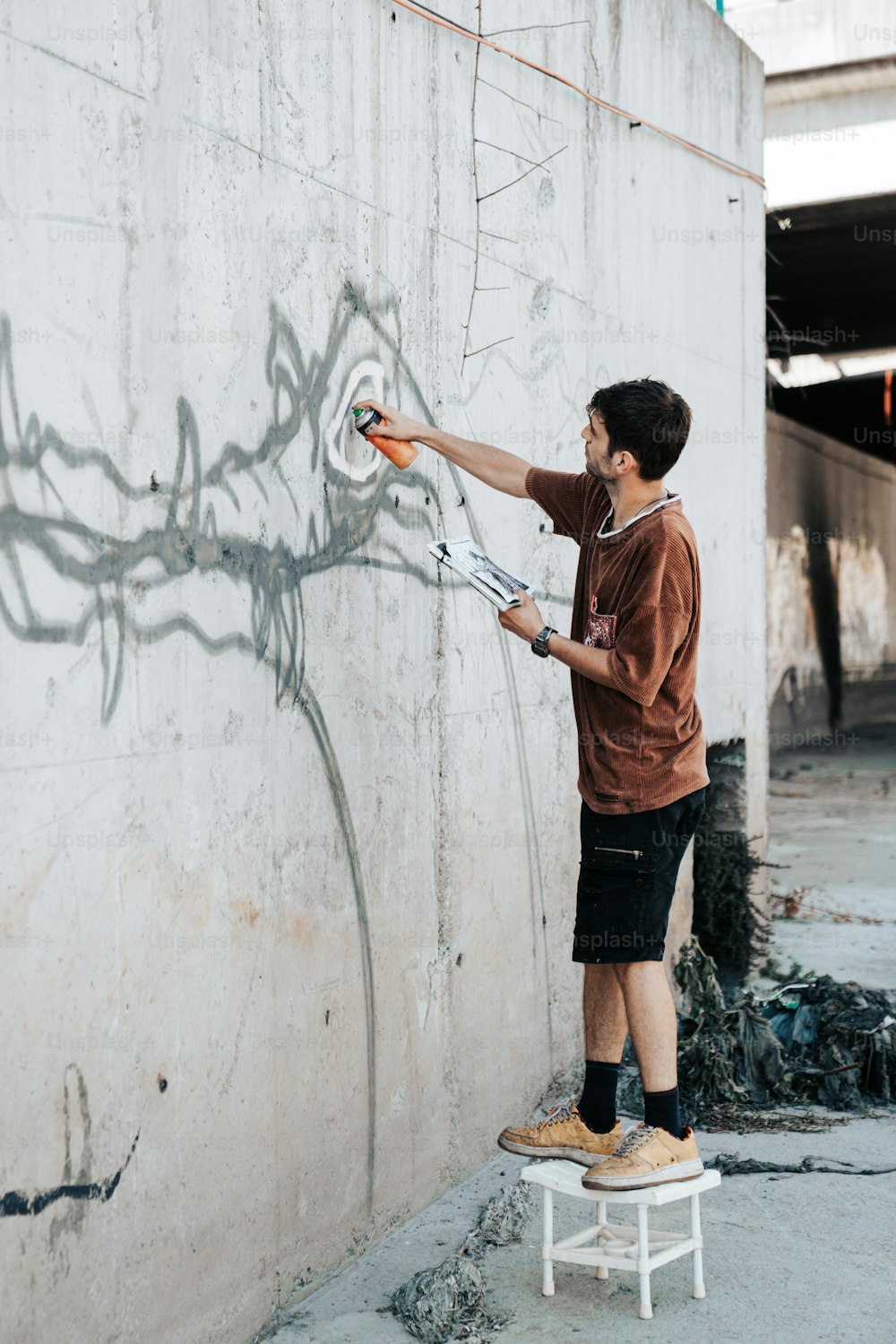 Ein Mann, der Graffiti an die Seite eines Gebäudes malt