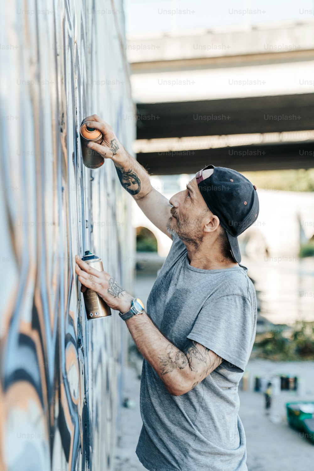 Ein Mann bemalt eine Wand mit Graffiti