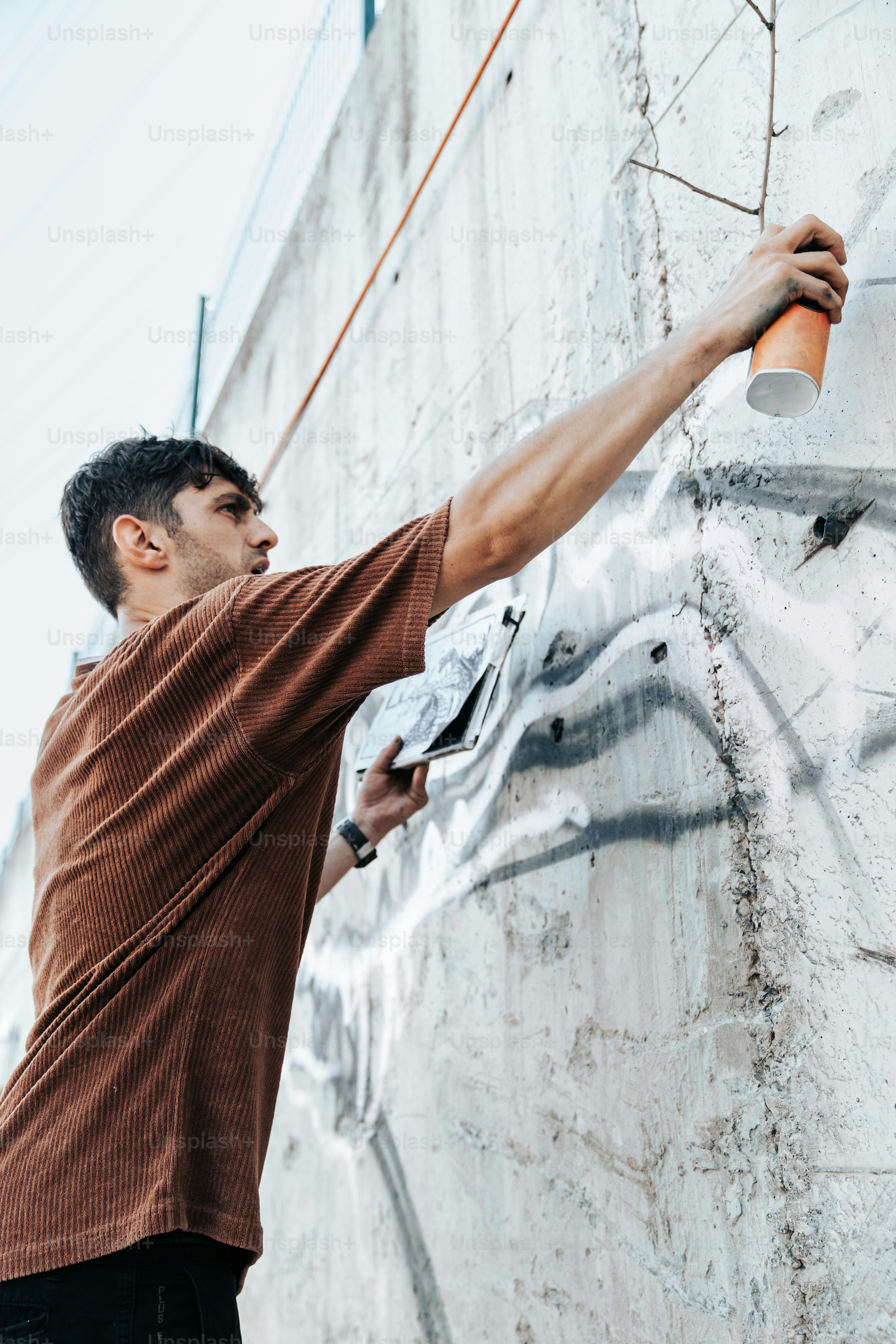 A man is painting graffiti on a wall photo – Graffiti Image on Unsplash