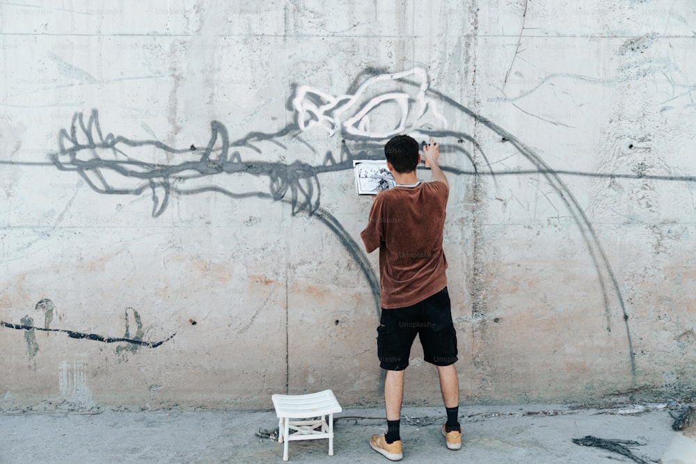 Ein Mann, der vor einer Wand mit Graffiti steht