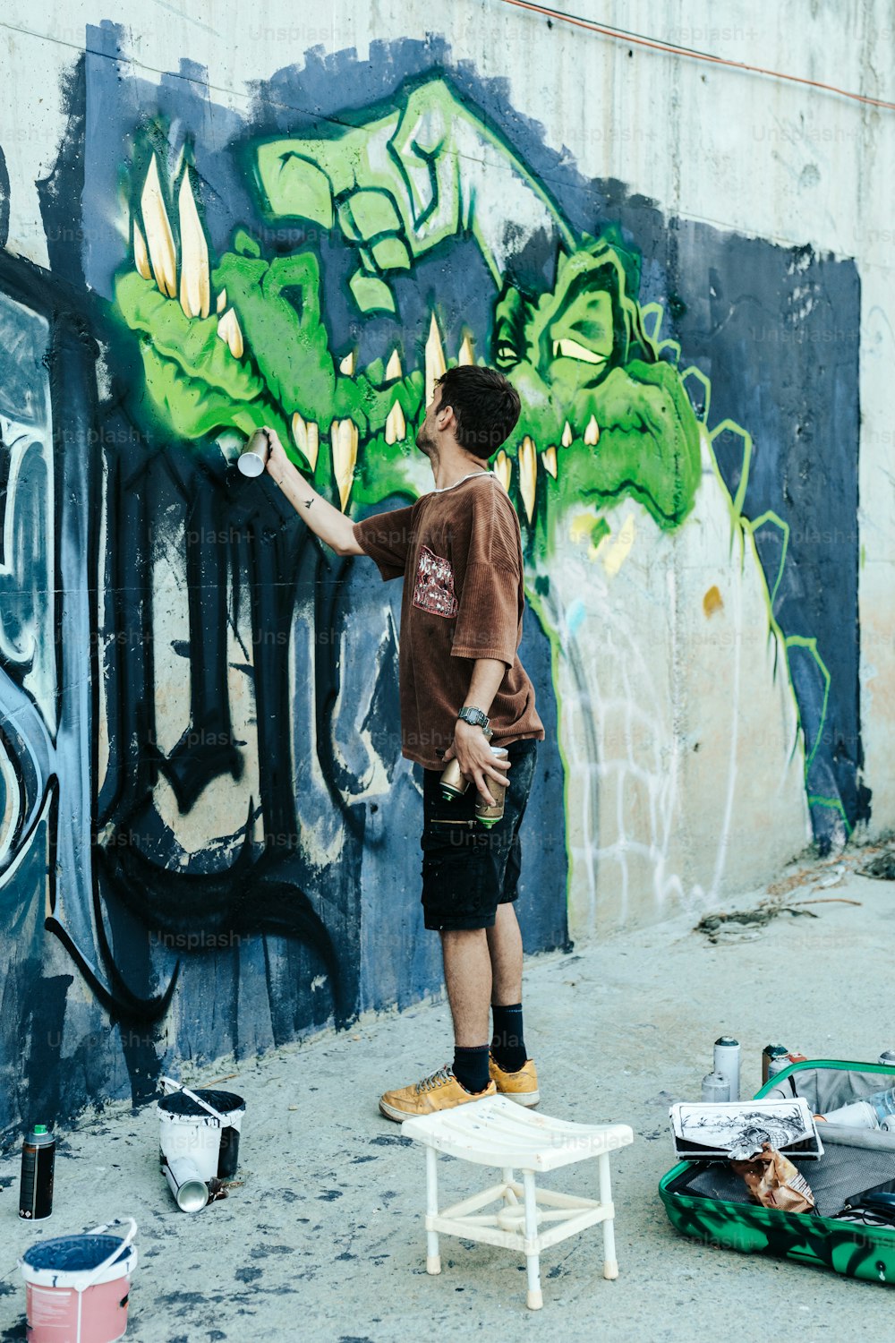 a man is painting a wall with graffiti