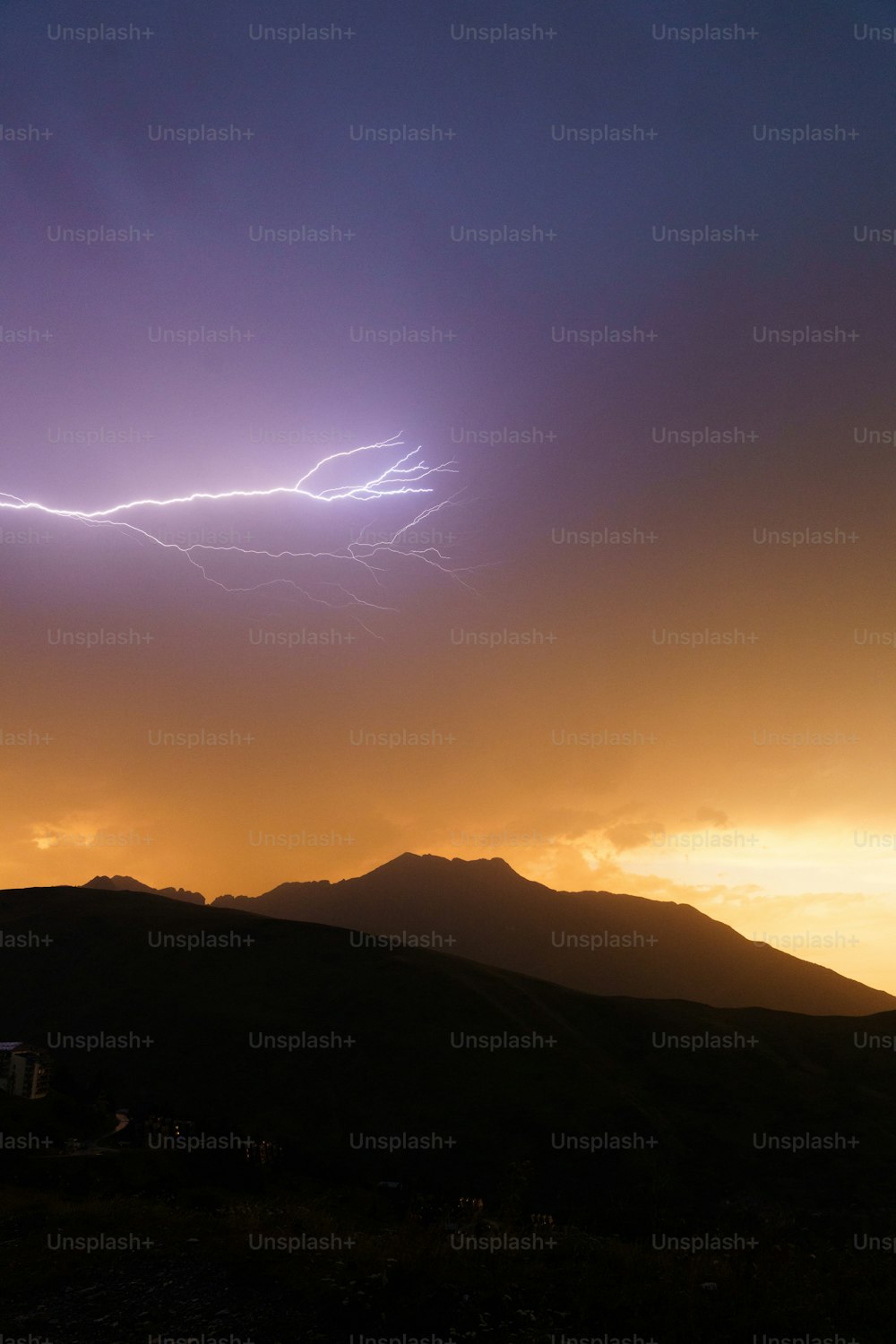 a lightning bolt is seen in the sky above a mountain