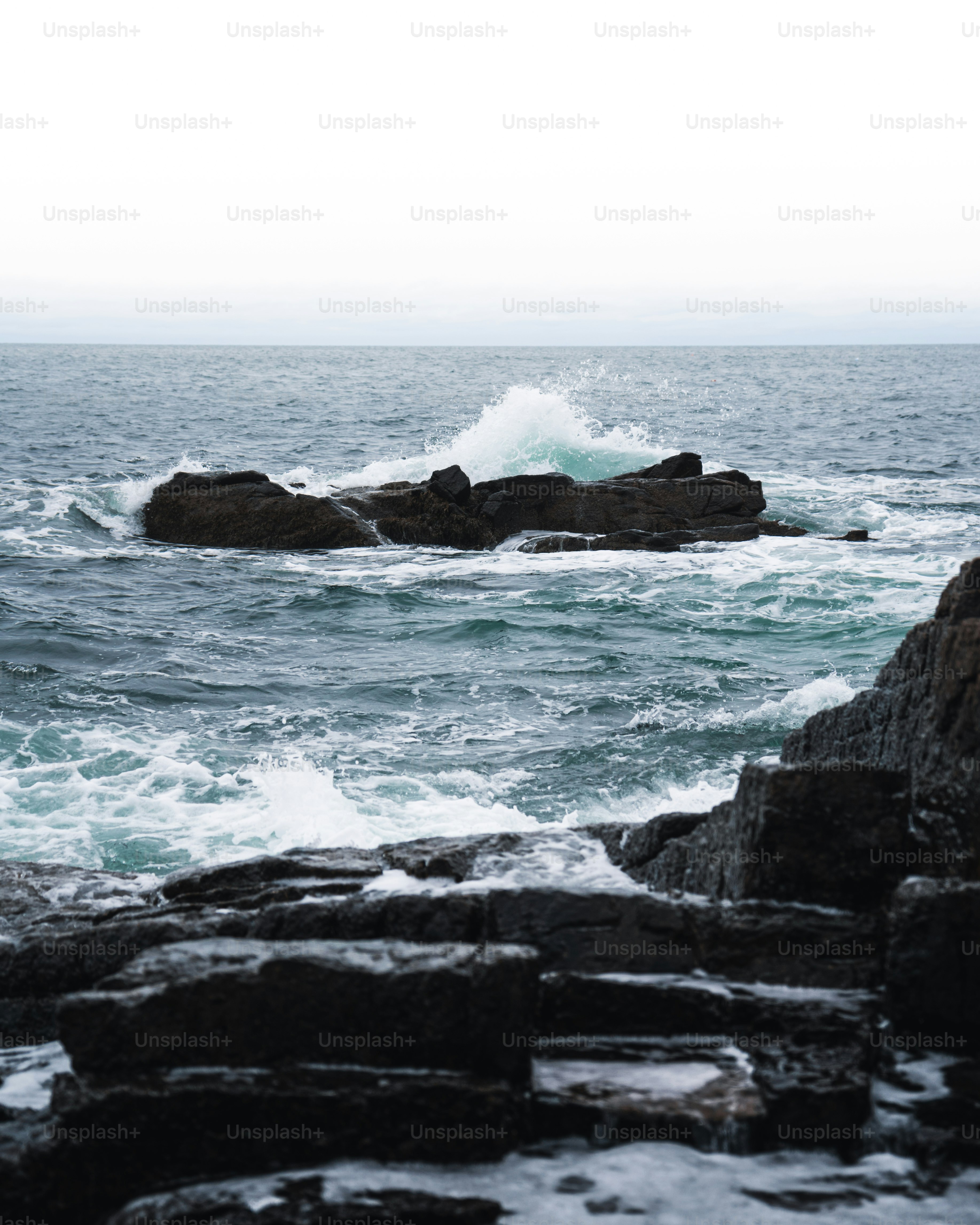 Un grande specchio d'acqua seduto accanto a una costa rocciosa