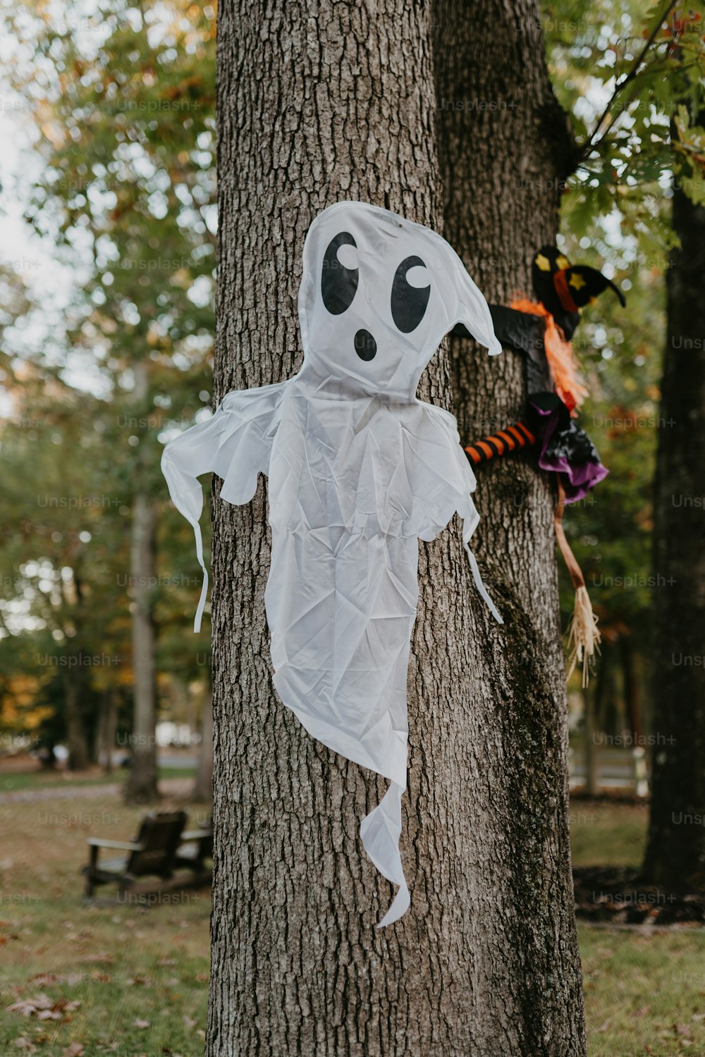 a ghost hanging from a tree in a park