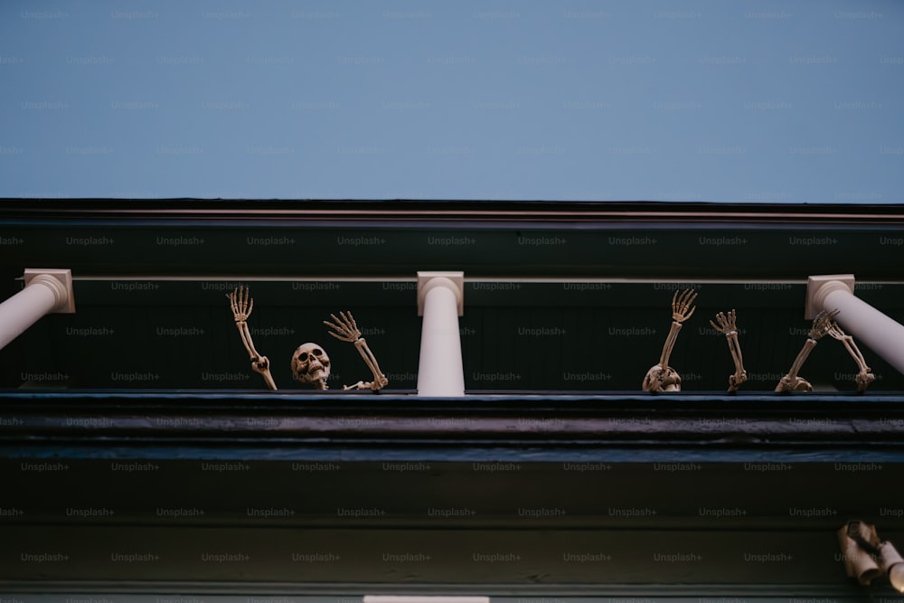 a group of skeleton figurines sitting on top of a building