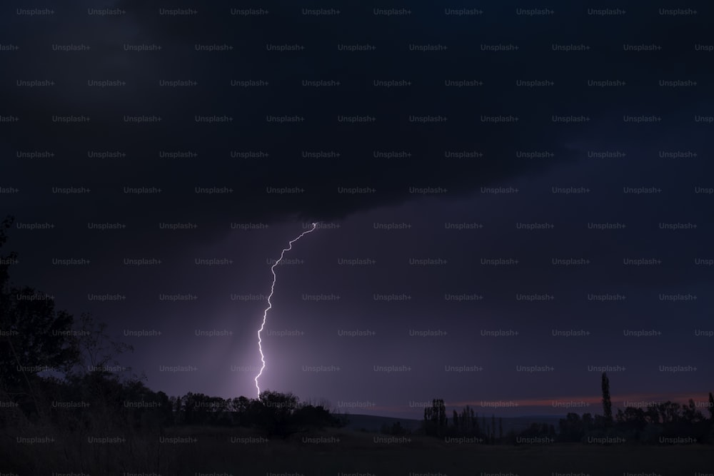 Un rayo se ve en el cielo sobre un campo