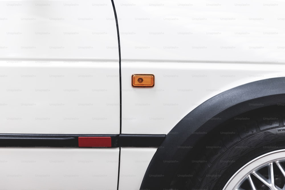 a close up of a white car with a red light