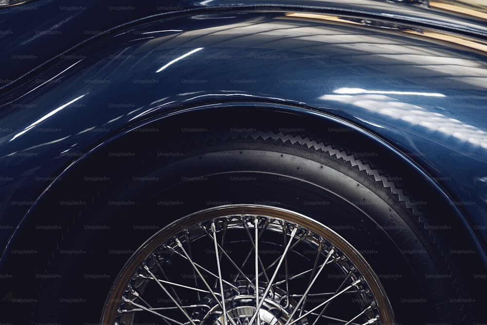 a close up of the front wheel of a blue car