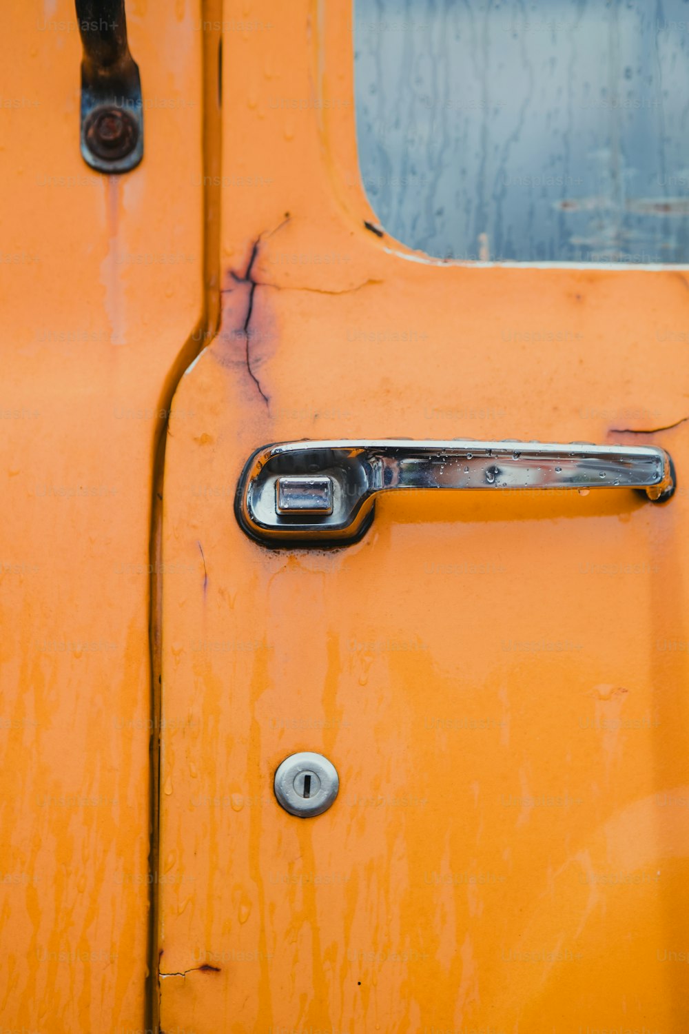 a close up of a door handle on a yellow vehicle